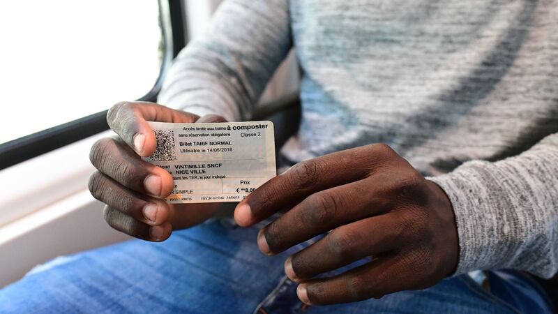 A migrant shows his train ticket as he attempts to cross the border from Ventimiglia in Italy to Menton in France. Photograph: Miguel Medina/AFP/Getty I