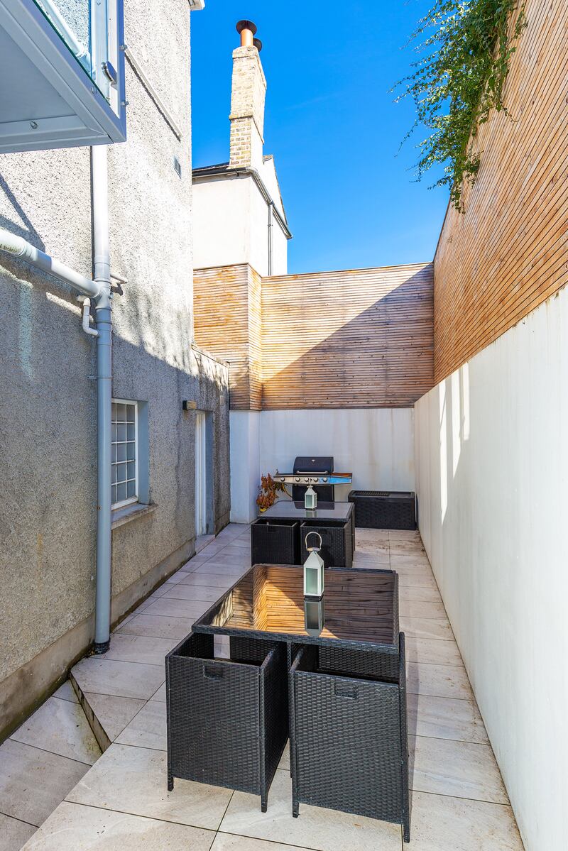 The south-facing courtyard to the rear of the property with access from the basement; it gets good sun during the day and is clad in concrete and cedar.