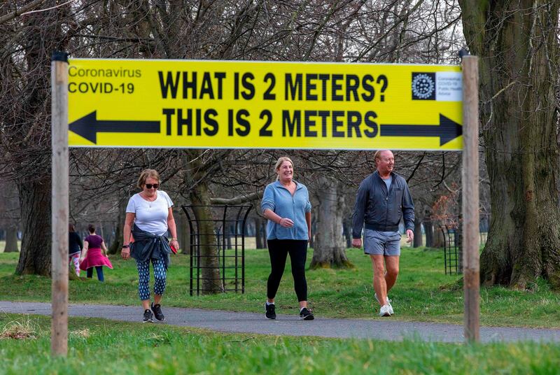 A sign notifies passers by of the 2 meter social distancing measures in place, as people exercise in Phoenix Park in Dublin, on March 25th. Photograph: Paul Faith/AFP via Getty Images