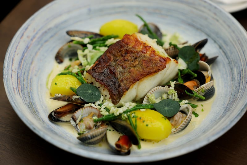Pan-roasted Atlantic cod with cockles and mussels veloute, saffron potatoes, pak choy, samphire and cauliflower 