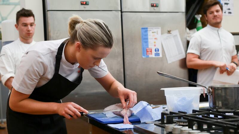 Grainne Mullins filleting her fish under close observation from judge Jordan Bailey.