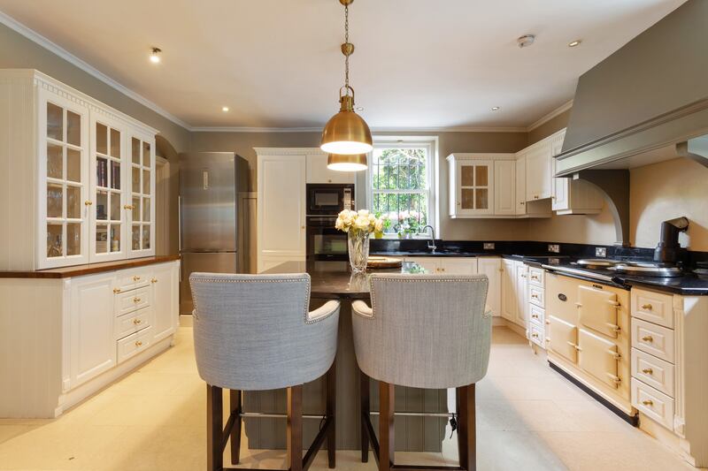 The kitchen is fitted out with cream-painted timber units and granite worktops.