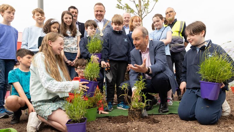 Micheál Martin planting flowers with students from Ballintemple National School at  the official opening of phase one of Marina Park, Cork. Photograph: Darragh Kane