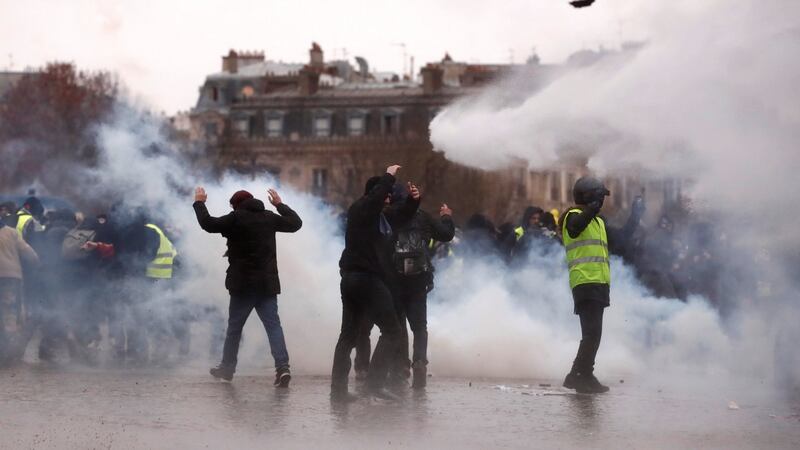 Protesters amid the tear gas near the Arc de Triomphe. Photograph: Reuters