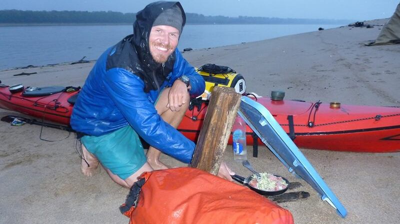 Henk van der Klok cooking dinner in the rain on the banks of the Mississippi, during a source to sea paddle of the entire river