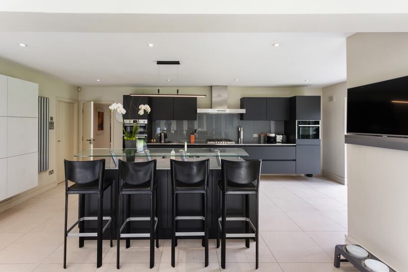 The central island in the kitchen features a breakfast bar. 
