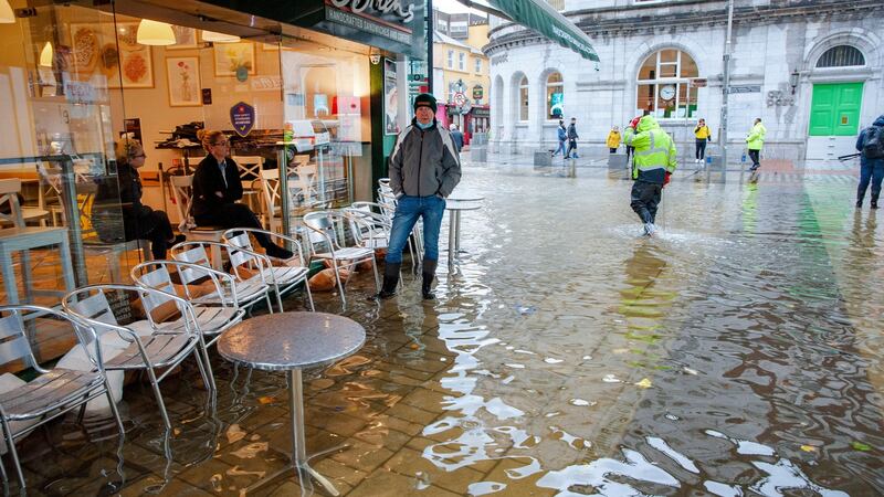O’Briens coffee shop staff pictured during heavy flooding on Winthrop street, Cork. Photograph: Daragh Mc Sweeney/Provision