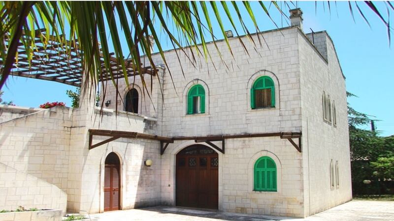 Stone house in Puglia, Italy, has a large garden where fruit trees grow