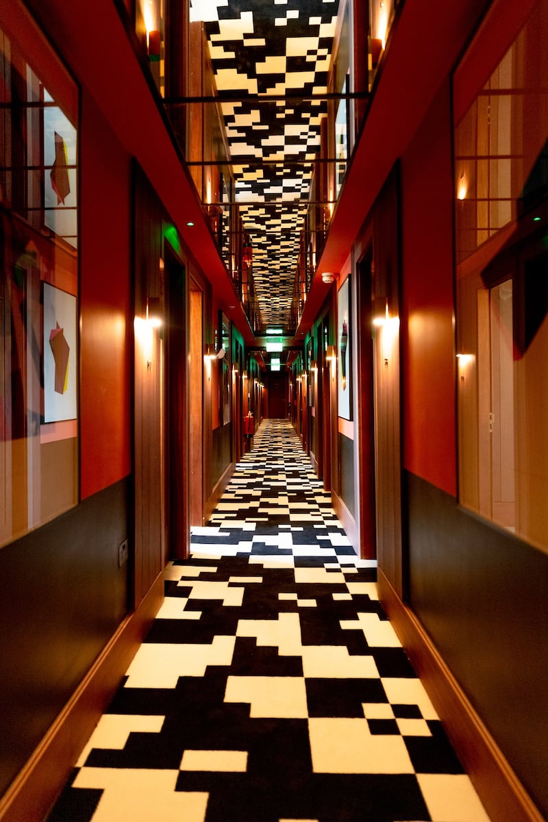 Each of the bedroom floors has a striking corridor of geometric black and white carpet.