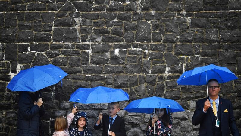 Children  wait amid the rain ahead of a visit by  Pope Francis to Knock Shrine in Co Mayo last weekend. Photograph: Dylan Martinez/Reuters