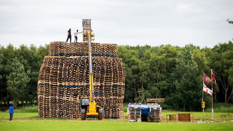 Masked men continue to build a bonfire at Inverary Playing Fields in Belfast. Police in Northern Ireland have warned their resources could be stretched amid growing fears of tension around the burning of Eleventh night bonfires. Photograph: PA Wire
