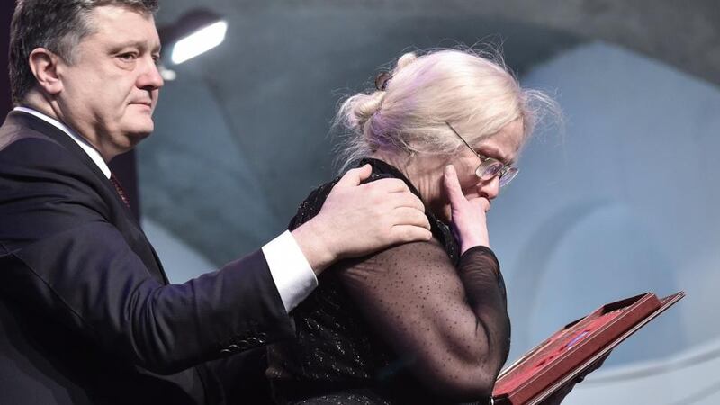 Ukrainian president Petro Poroshenko hands  a relative of a dead  activist the Order of Hero of Ukraine as part of  ceremonies marking the first anniversary of the killings of demonstrators in the final act of a dramatic uprising around Independance Square in Kiev. Photograph: Mykola Lazarenko/AFP/Getty Images.