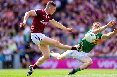 Galway's Johnny Heaney kicks past Stephen O’Brien of Kerry. 
Photograph: James Crombie/Inpho