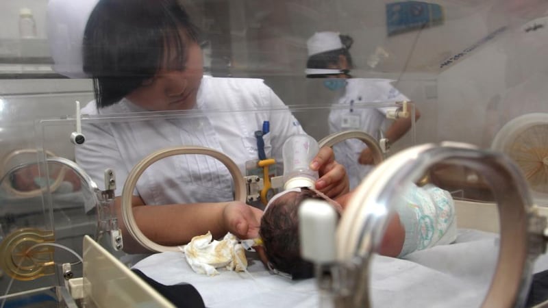 Recovering: a nurse feeds Baby 59. Photograph: STR/AFP/Getty