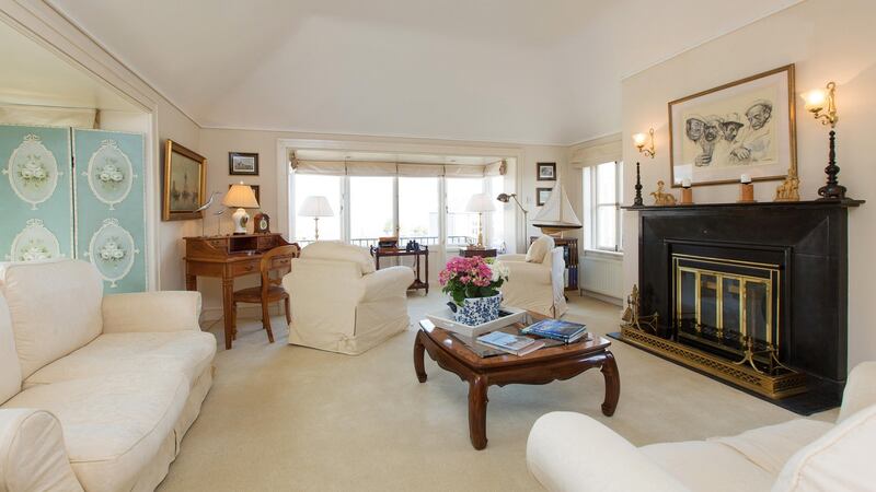 Folding double doors open into a large livingroom with a box bay window looking across Dublin Bay