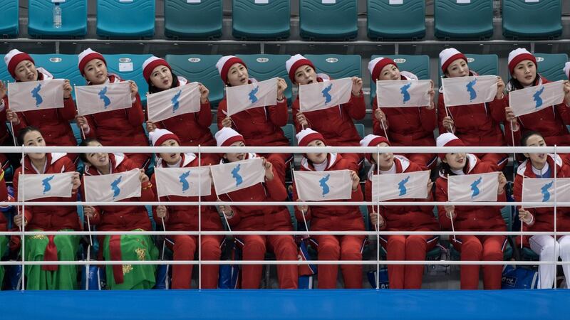 North Korean cheerleaders wave flags showing a unified Korean peninsula. Photo: Ed Jones/Getty Images