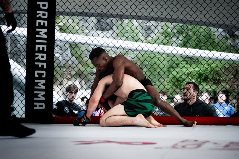 Altesse Mukonkole grapples Eoin Hennessy against the cage at Premier MMA at Ballykeefe Amphitheatre in June.  Photograph: Megan Ponomarenko