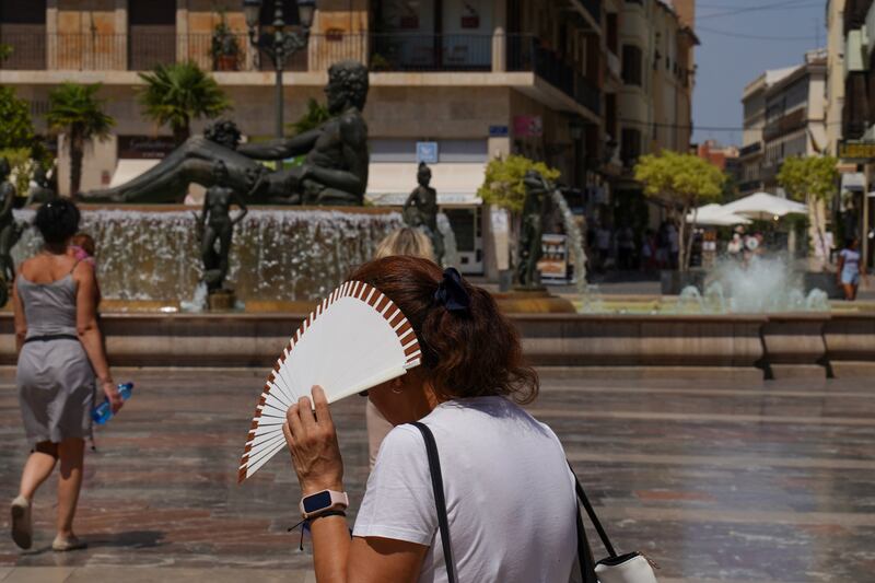 A woman uses a fan to shield her face from the sun in Valencia, Spain. Photograph: Michael Robinson Chavez/Bloomberg