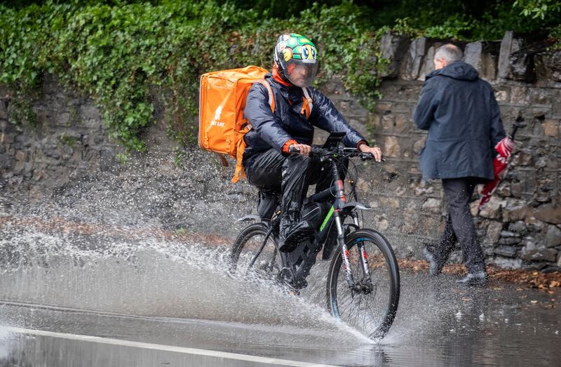 A delivery rider rides through heavy rainwater on Conyngham Road, Dublin, in July 2023. Photograph: Colin Keegan/Collins Dublin