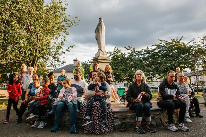 Local residents of the Tenters, Dublin 8, watching the screening of new documentary promoting the housing scheme, in Oscar Square. Photograph Tiberio Ventura / The Irish Times