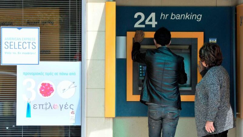 Small queues of people have gathered at cash machines across Cyprus to withdraw money, while co-operative credit societies had to shut yesterday to prevent a run on deposits. Photograph:  Yiannis Nisiotis/Reuters