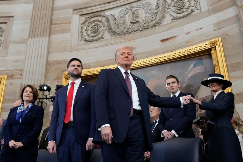 US president Donald Trump holds the hand of his wife Melania Trump as their son, Barron Trump, vice-president JD Vance and Senator Amy Klobuchar look on after taking the oath of office on Monday. Photograph: Morry Gash/Getty