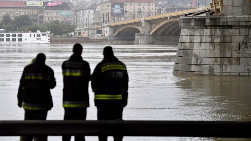 Firemen stand at Margaret Bridge, where the wreck of a capsized cruise ship was found on the Danube in dowtown Budapest, Hungary. Photograph: EPA