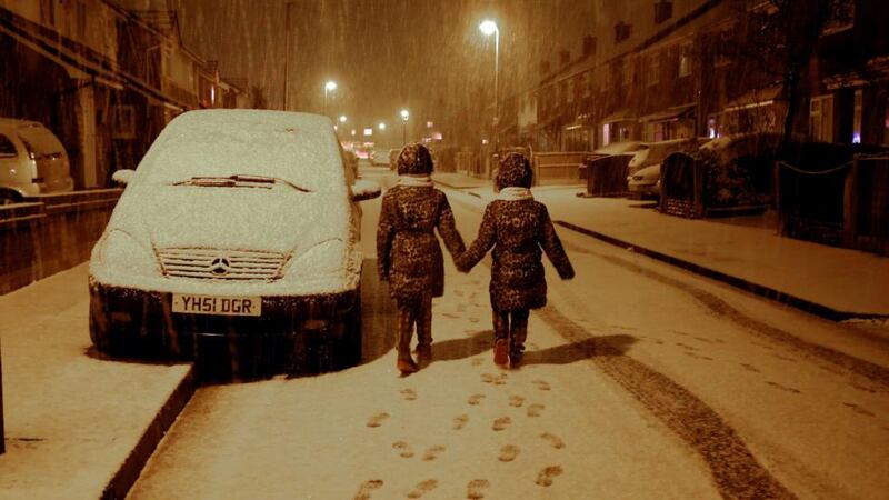 Maisy Byrne, aged nine, (left) and her sister Lulu , aged seven, have fun as snow falls on Boxing Day in Gateacre, Liverpool. Photograph: PA
