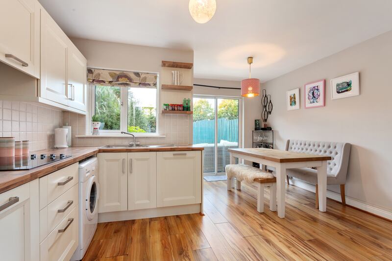 The kitchen units are white with chrome fittings and have a durable wood-effect countertop.