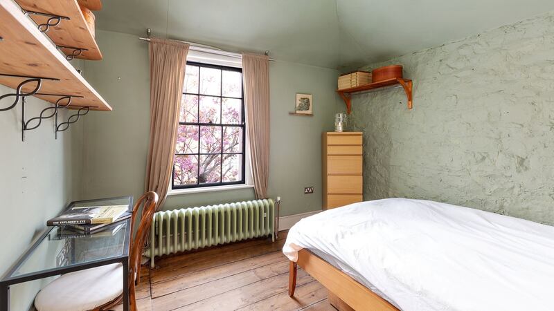 The  exposed stone bedroom walls appear to be finished in a   lime render