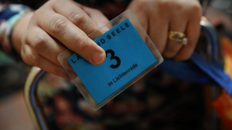 A young woman holds her admittance card while waiting to choose groceries at the centre. Photograph: Sean Gallup/Getty Images
