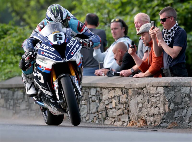Michael Dunlop wheelies his Tyco BMW past the spectators at Sulby Bridge during the 2018 Isle of Man TT.  Photograph: Stephen Davison

