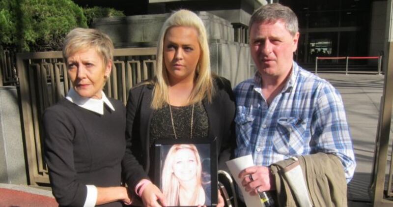 Andrea Furlong holds a photograph of her sister Nicola outside Tokyo District Court with her father Andrew and mother Angela today.