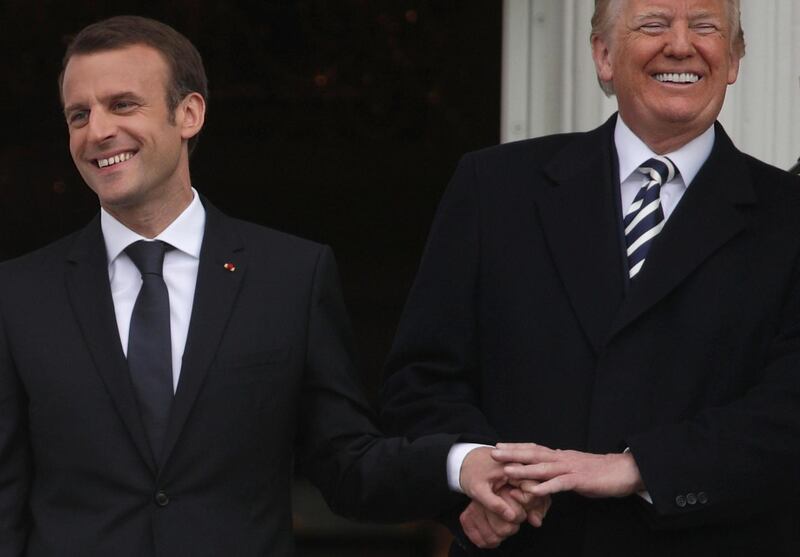 US President Donald Trump and French President Emmanuel Macron hold hands during a state arrival ceremony at the White House. Photograph: Alex Wong/Getty Images