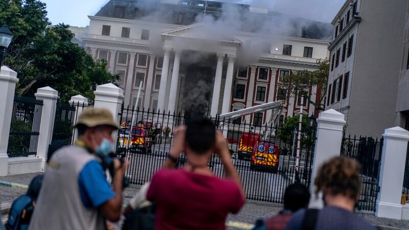 Members of the media film as smoke billows from the National Assembly building in Cape Town on Sunday. Photograph: Joao Silva/The New York Times