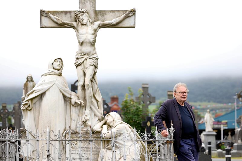 Historian Tom Hartley beside the memorial to Sir John Burke, a wealthy shipping magnate, at Milltown Cemetery, Belfast. Photograph: Stephen Davison