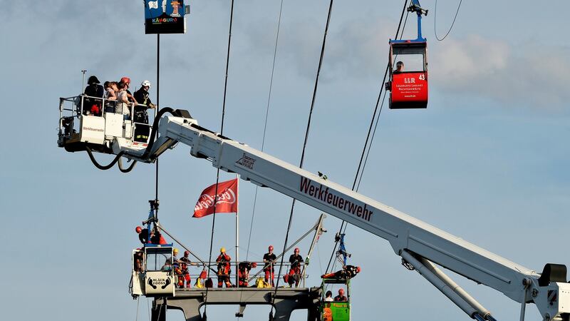 Fire crews evacuate passengers from suspended cable cars that run over the river Rhine. Photograhp: Sascha Steinbach/EPA