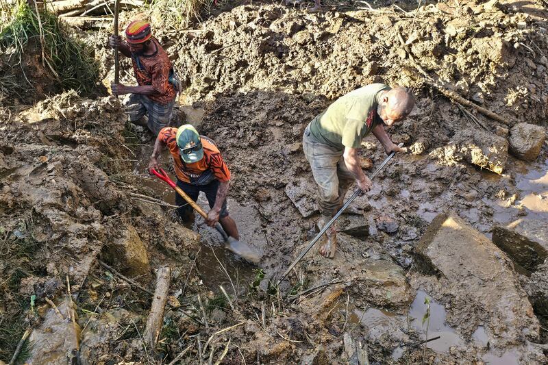 People dig through debris at the site of a landslide in Yambali village in  Enga Province, Papua New Guinea. Photograph: Emmanuel Eralia/AFP via Getty Images