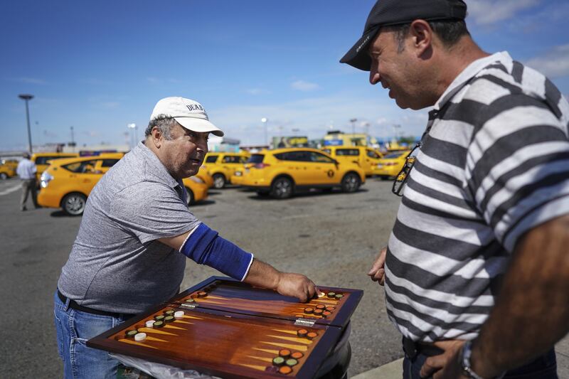 Rabi Musaav and Joseph Kuinov, two cab drivers, played backgammon while waiting for customers at a lot at Kennedy International Airport in New York City.