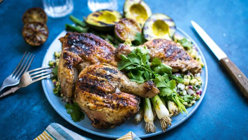 Summer eating: brick chicken with avocado, spring onions, coriander, corn salsa and lime halves