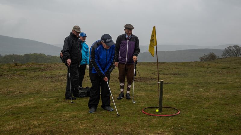 A golfer hits the ball into a red ring around the flagstick which is counted as sinking a shot during a competition for charity at the reborn Rhayader Golf Links in Rhayader, Wales. Photograph: Phil Hatcher-Moore/The New York Times