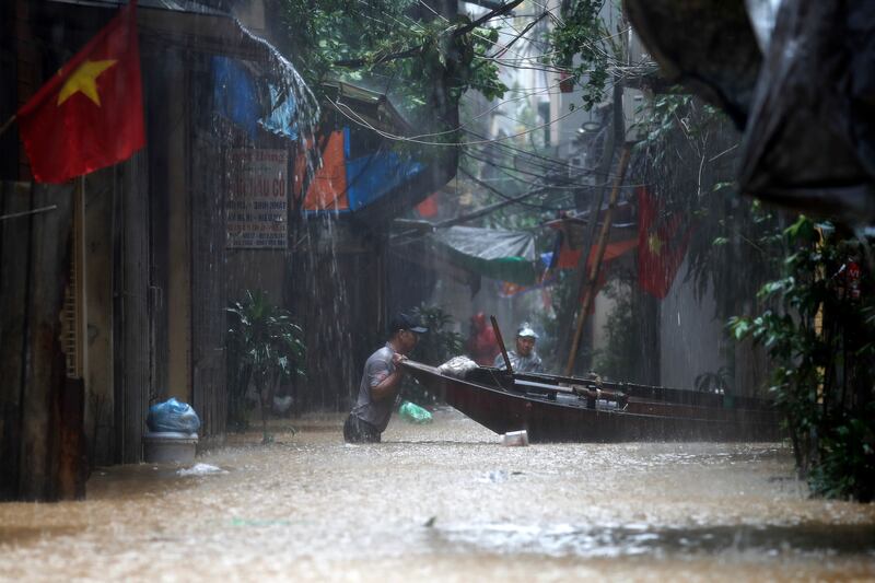 Local residents use a boat floating on a flooded street in Hanoi on Wednesday. Photograph: Luong Thai Linh/EPA