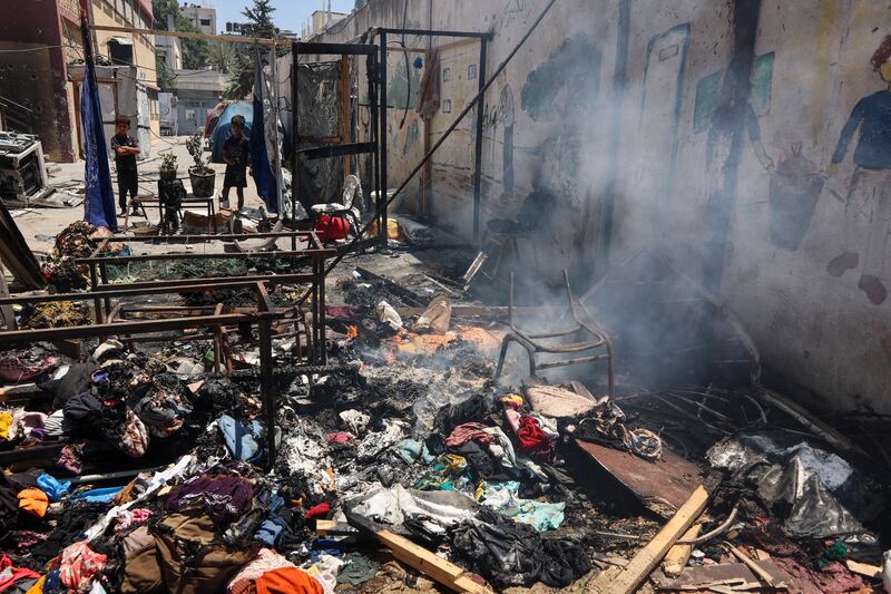 Children look at smouldering debris at Gaza City's Mustafa Hafez school, which has been sheltering Palestinians displaced by the war. Photograph: Omar Al-Qattaa/Getty