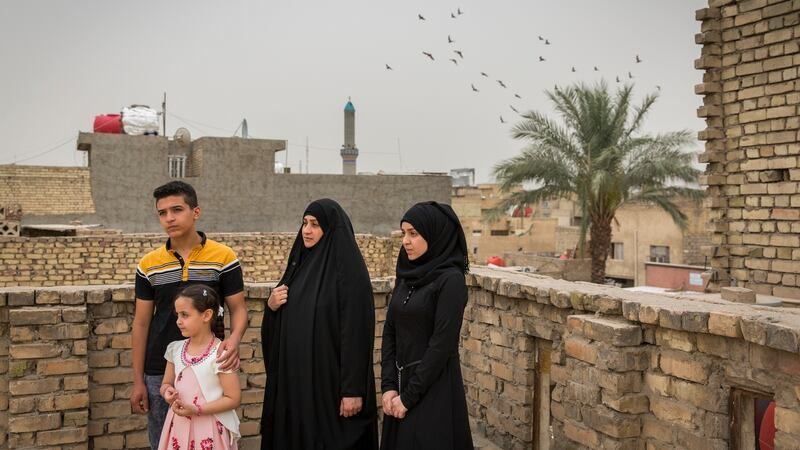 Captain Harith al-Sudani’s wife, Raghad Hasan Chaloob, centre, and their three children, Riyam, Rawan and Muamal on the roof of their home in Baghdad. Photograph:  Ivor Prickett/The New York Times