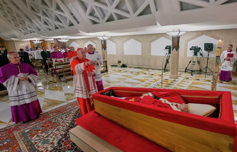 Cardinal camerlengo Kevin Farrell (centre) flanked by master of ceremonies Archbishop Diego Giovanni Ravelli (left) and master of ceremonies Lubomir Welnitz (right) performs the ceremonial aspersion of the body of Pope Francis with holy water as part of the final rites inside his private chapel at the Vatican on Monday. Photograph: Vatican Media/AP