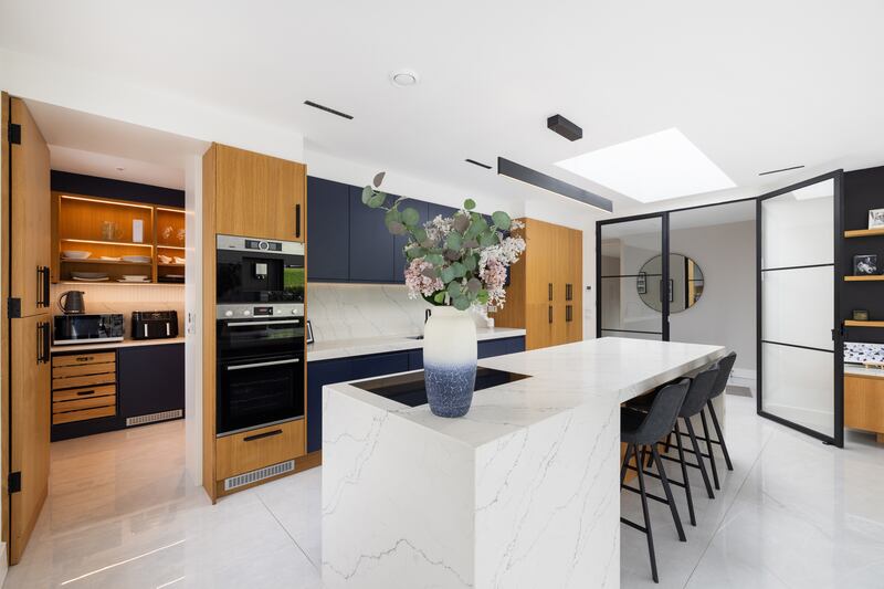 A well appointed pantry serves the streamlined kitchen
