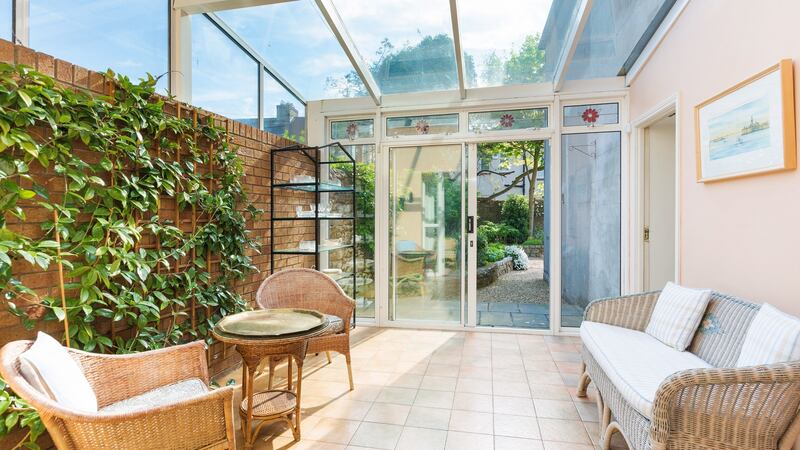 The sun room features a tiled floor, exposed brick wall and sliding patio doors on to the rear patio.