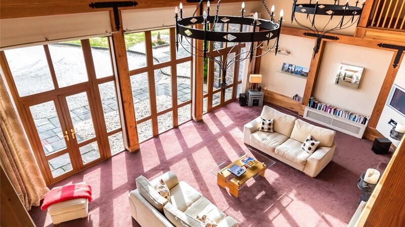 The living room at Cappanacush Heights has floor-to-ceiling windows and is overlooked by a first-floor gallery.