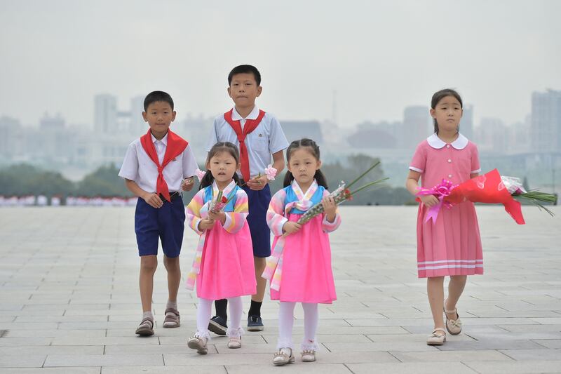 Schoolchildren arrive to pay their respects before the statues of late North Korean leaders Kim Il-sung and Kim Jong-il at Mansu Hill in Pyongyang on Saturday, as North Korea marked the 75th anniversary of its foundation. Photograph: Kim Won-jin/AFP via Getty Images