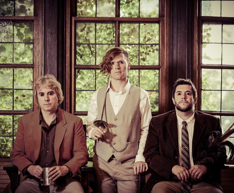 Three musicians, looking straight to camera: John McSherry (seated), Tyler Duncan (standing) and Michael Shimmin (seated)